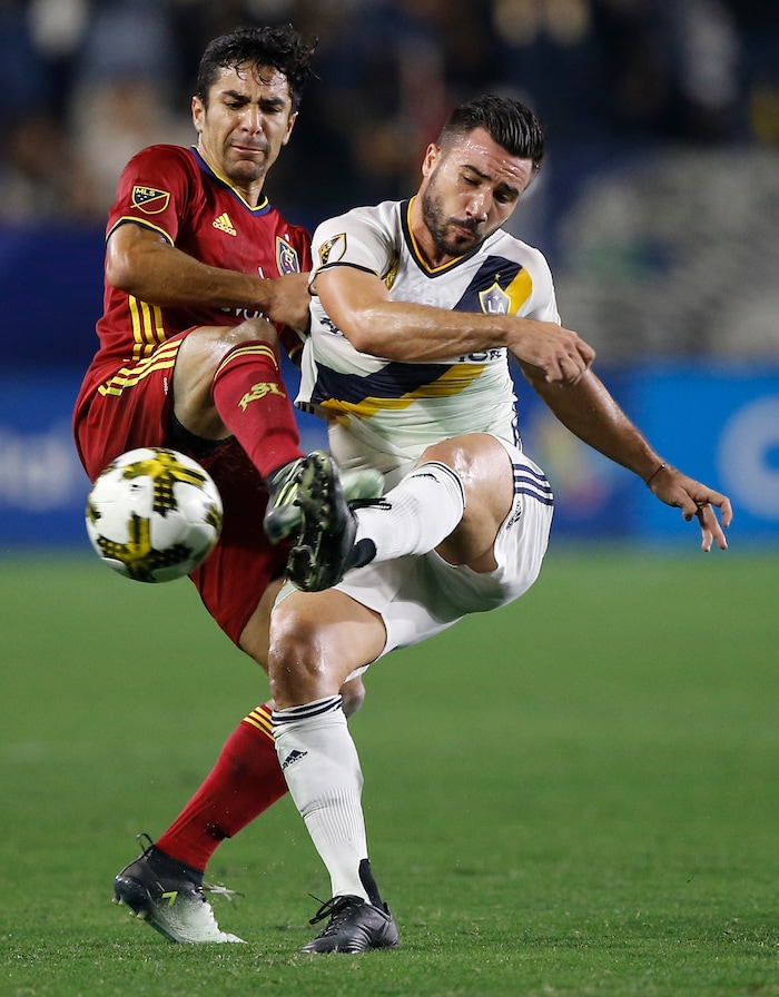 Real Salt Lake defender Tony Beltran, left, competes against Los Angeles Galaxy midfielder Romain Alessandrini (7) for the ball during the second half of an MLS soccer game in Carson, Calif., Saturday, Sept. 30, 2017. (AP Photo/Alex Gallardo)