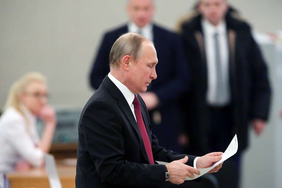 Russian President and Presidential candidate Vladimir Putin prepares to cast his ballot during Russia's presidential election in Moscow, Russia, Sunday, March 18, 2018. Putin's victory in Russia's presidential election Sunday isn't in doubt. The only real question is whether voters will turn out in big enough numbers to hand him a convincing mandate for his fourth term and many Russian workers are facing intense pressure to do so. (Sergei Chirikov/Pool Photo via AP)