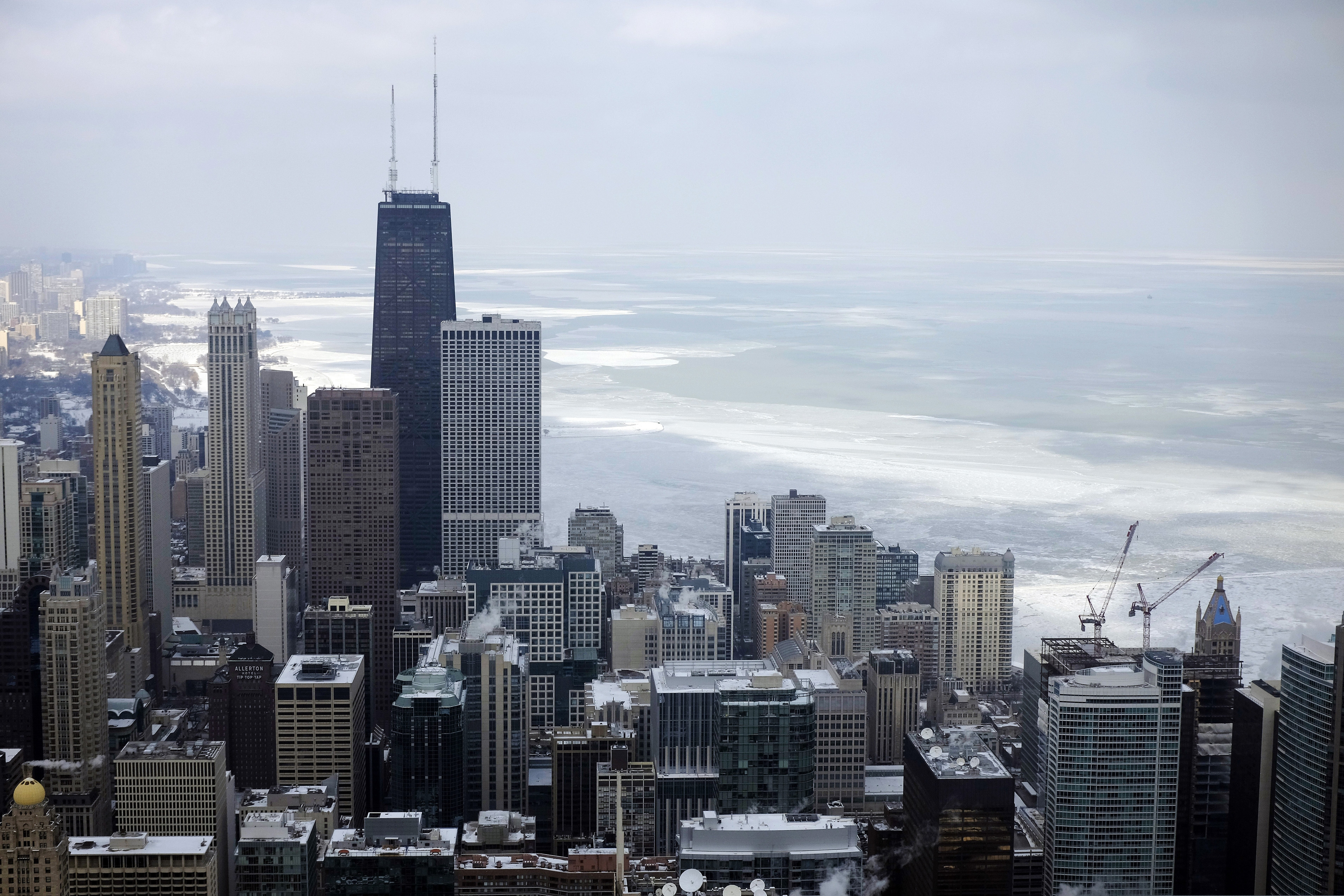 FILE - In this Feb. 17, 2015, file photo, ice covered Lake Michigan is seen behind downtown skyline, in Chicago.  (AP Photo/Kiichiro Sato, File)