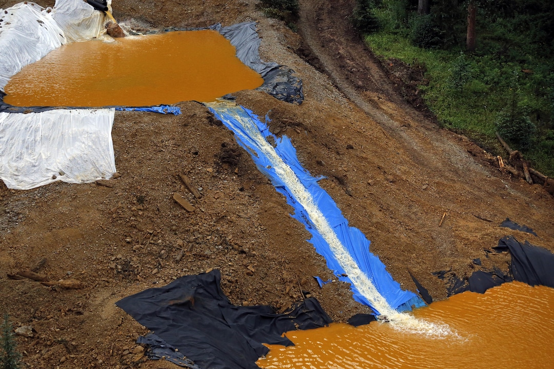 Water flows through a series of retention ponds built to contain and filter out heavy metals and chemicals from the Gold King mine wastewater accident, in the spillway about 1/4 mile downstream from the mine, outside Silverton, Colo., Wednesday, Aug. 12, 2015. The Environmental Protection Agency has taken full responsibility for the mine waste spoiling rivers downstream from Silverton, but people who live near the idled and leaking Gold King mine say local authorities and mining companies spent decades spurning federal cleanup help. (AP Photo/Brennan Linsley)