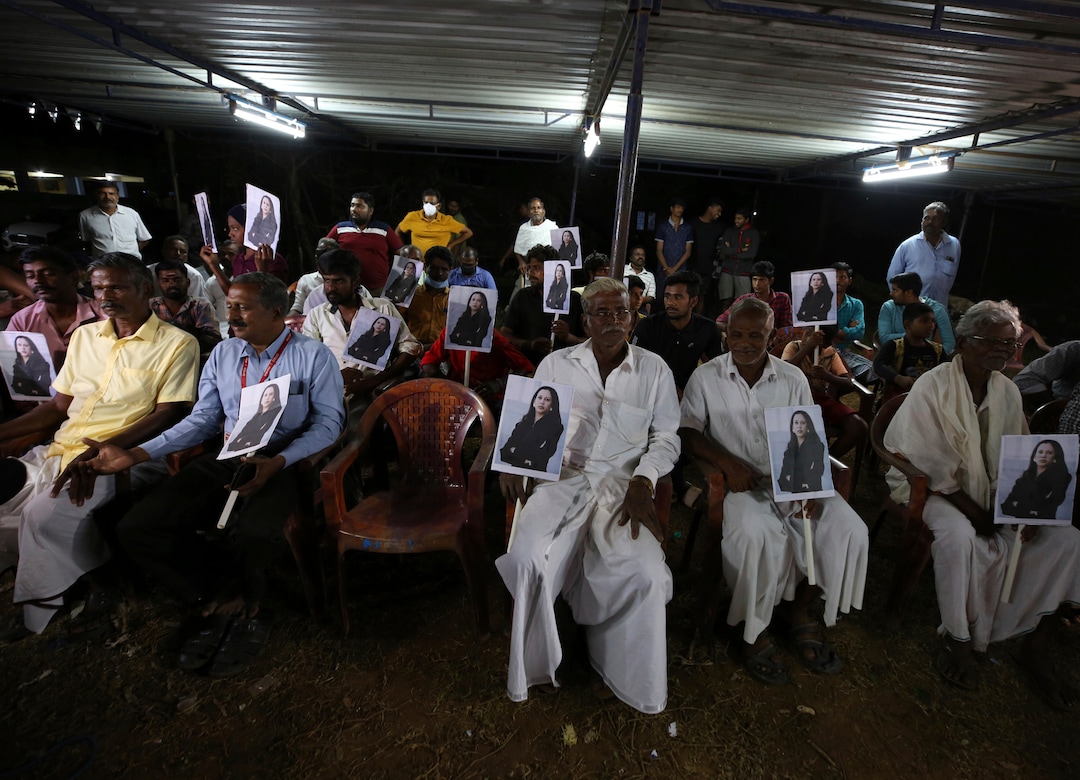 Villagers hold placards featuring U.S. Vice President-elect Kamala Harris as they watch the live telecast of the inauguration ceremony, in Thulasendrapuram, the hometown of Harris' maternal grandfather, south of Chennai, Tamil Nadu state, India, Wednesday, Jan. 20, 2021. Residents of a tiny Indian village surrounded by rice paddies flocked to a Hindu temple, setting off firecrackers and praying and as they watched Kamala Harris, who has strong roots to the village, take her oath of office and become the U.S. vice president on Wednesday. (AP Photo/Aijaz Rahi)