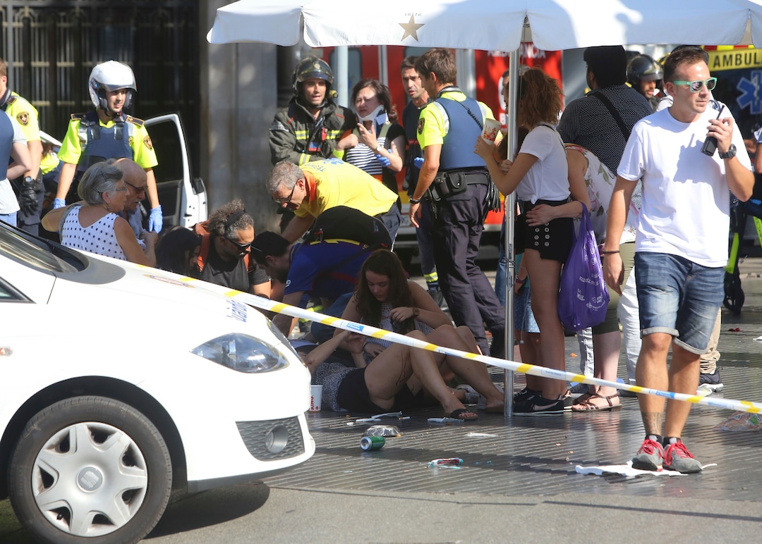 Injured people are treated in Barcelona, Spain, Thursday, Aug. 17, 2017 after a white van jumped the sidewalk in the historic Las Ramblas district, crashing into a summer crowd of residents and tourists and injuring several people, police said. (AP Photo/Oriol Duran)