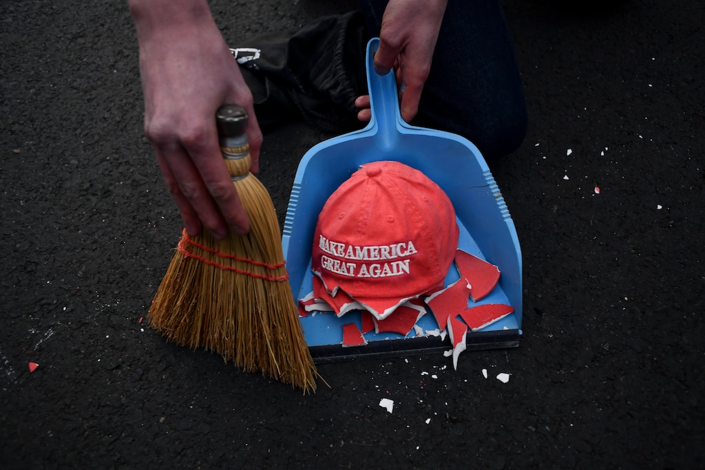 (Kenny Holston | The New York Times)
A broken decorative MAGA hat is swept up during a demonstration against Donald Trump on Election Day in Washington, Nov. 3, 2020.