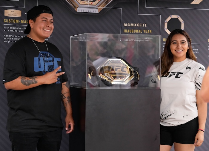 (Francisco Kjolseth | The Salt Lake Tribune) Will and Carol Sanchez pose for a photograph with an official UFC championship belt outside of Vivint Arena in Salt Lake on Saturday, Aug. 20, 2022, before the start of UFC 278 fights. 