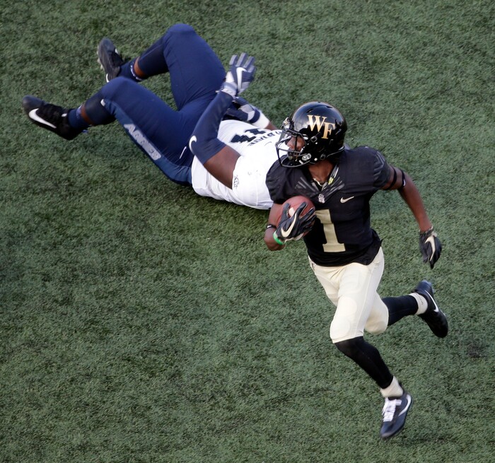 Wake Forest's Tabari Hines (1) runs past Utah State's Devon Anderson (91) after a catch in the second half of an NCAA college football game in Winston-Salem, N.C., Saturday, Sept. 16, 2017. (AP Photo/Chuck Burton)