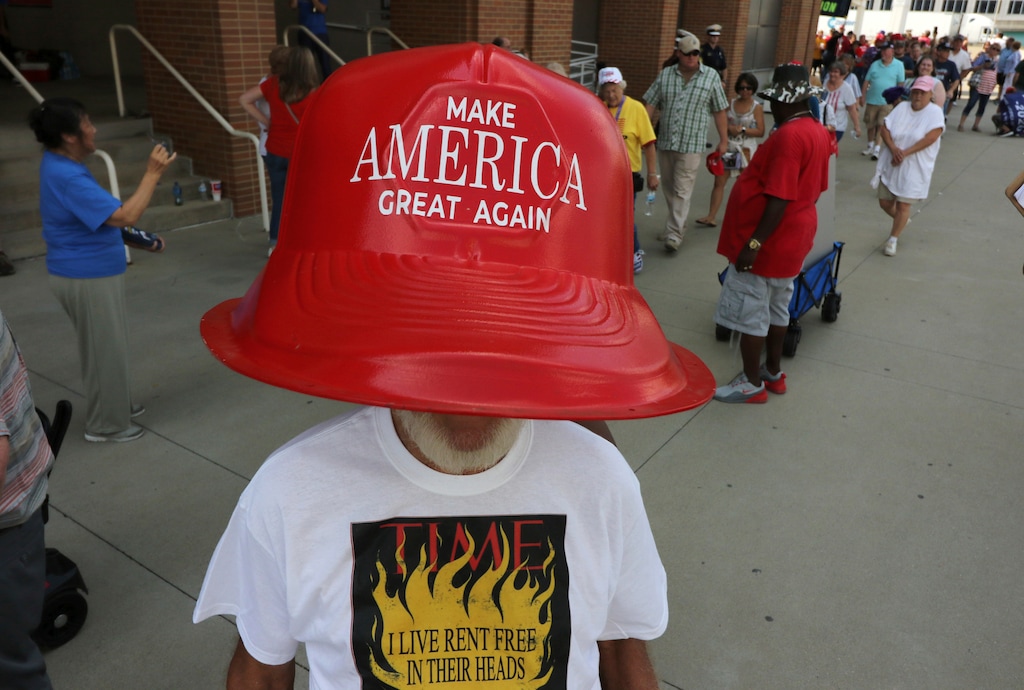 (Gary Landers | AP) Robert Morris, of Jasper, Tenn., wears a giant hat as he waits in line to enter a rally by President Donald Trump Thursday, Aug. 1, 2019, in Cincinnati.