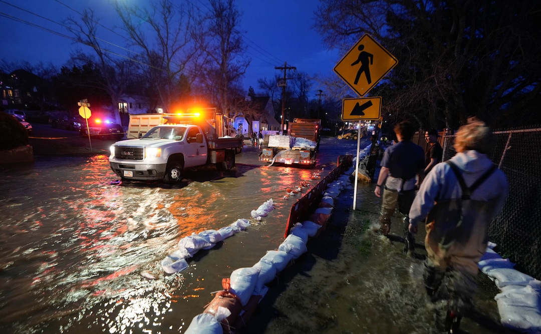 (Francisco Kjolseth | The Salt Lake Tribune) People work to protect homes into the night along 1700 South in Salt Lake City from the rising flow of Emigration Creek through Wasatch Hollow Park on Wednesday, April 12, 2023. 
