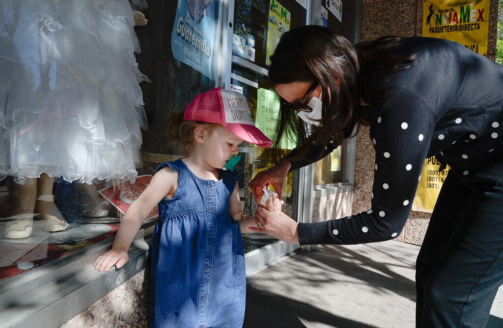(Francisco Kjolseth  |  The Salt Lake Tribune) Tiffany Clason squirts hand sanitizer on the curious hands of her daughter Margaux, 2, as they visit historic Midvale on Wednesday, April 29, 2020.