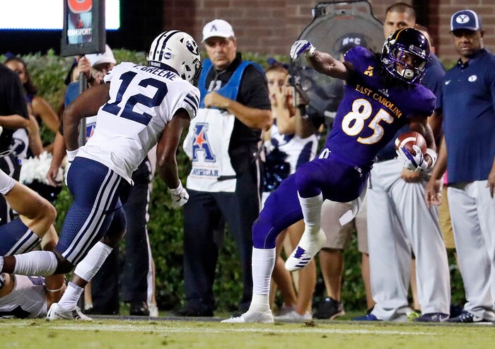 East Carolina's Davon Grayson (85) tries to get his feet down in bounds after catching a pass in front of BYU's Trevion Greene (12) during the first half of an NCAA college football game in Greenville, N.C., Saturday, Oct. 21, 2017. (AP Photo/Karl B DeBlaker)
