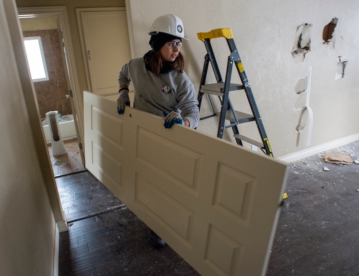 (Rick Egan  |  The Salt Lake Tribune)       Abby Chiesa removes a closet door from a home that will be demolished for freeway widening, for UDOT and Habitat for Humanity, Wednesday, Jan. 16, 2019.





