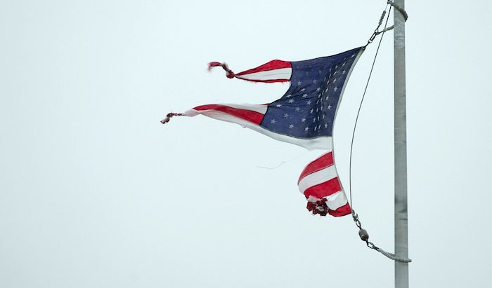 (Jay Janner | Austin American-Statesman via AP) A tattered U.S. flag whips in the wind in Geronimo, Texas, during Hurricane Harvey on Saturday August 26, 2017.