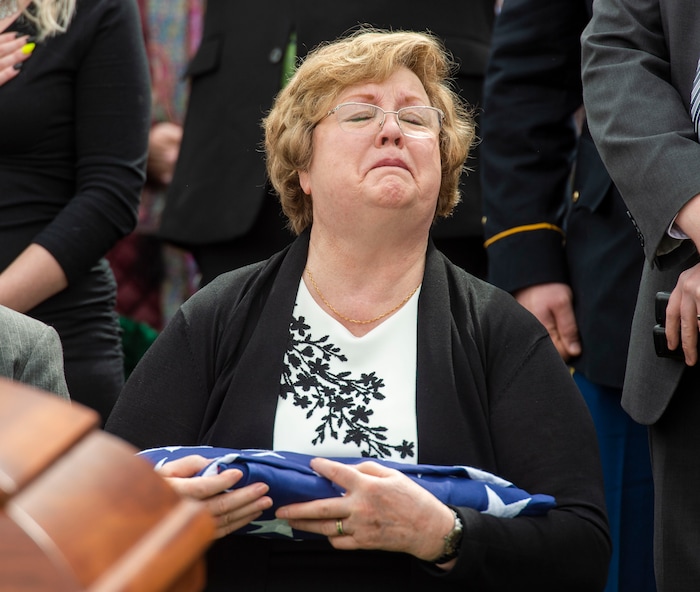(Rick Egan  |  The Salt Lake Tribune)     Mary Ann Turner, the daughter of 2nd Lt. Lynn W. Hadfield, holds the flag the was just preselected to her, from his casket during the graveside service for her father, who was killed during the Second World War, at Veterans Memorial Park, in Bluffdale. Thursday, March 21, 2019.


