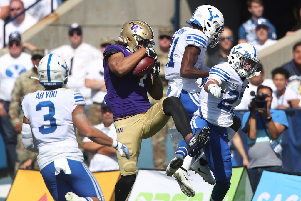 Washington tight end Hunter Bryant (1) catches the ball between BYU linebacker Chaz Ah You (3), BYU defensive back Isaiah Herron (11) and BYU defensive back Dimitri Gallow (22) during the first half of an NCAA college football game, Saturday, Sept. 21, 2019, in Provo, Utah. (AP Photo/George Frey)