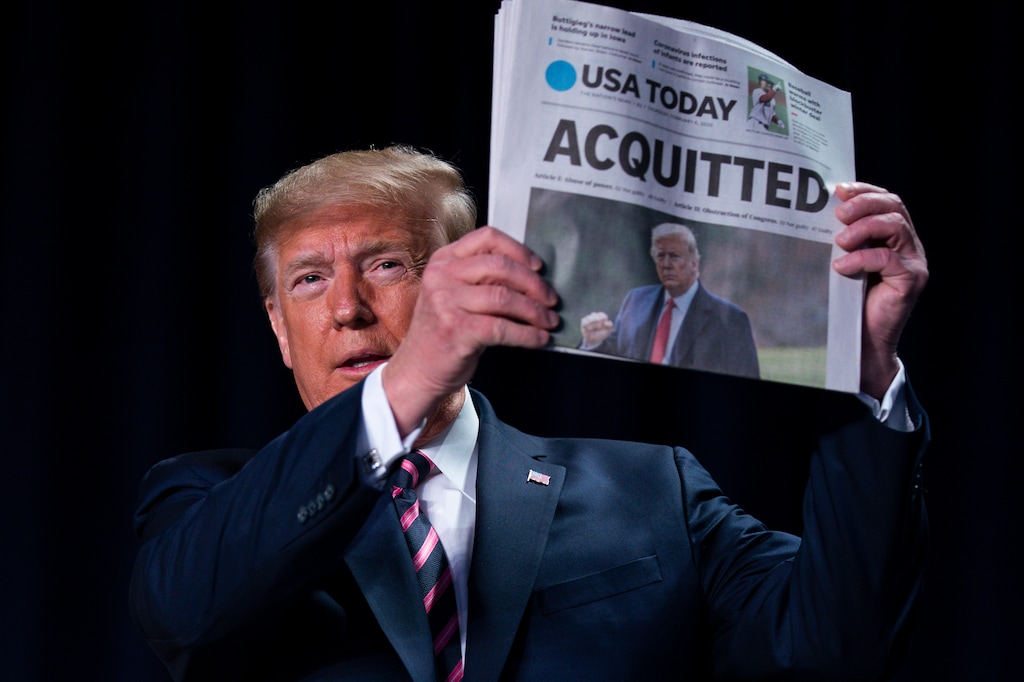 (Evan Vucci | AP) President Donald Trump holds up a newspaper with the headline that reads "ACQUITTED" at the 68th annual National Prayer Breakfast, at the Washington Hilton, Thursday, Feb. 6, 2020, in Washington.