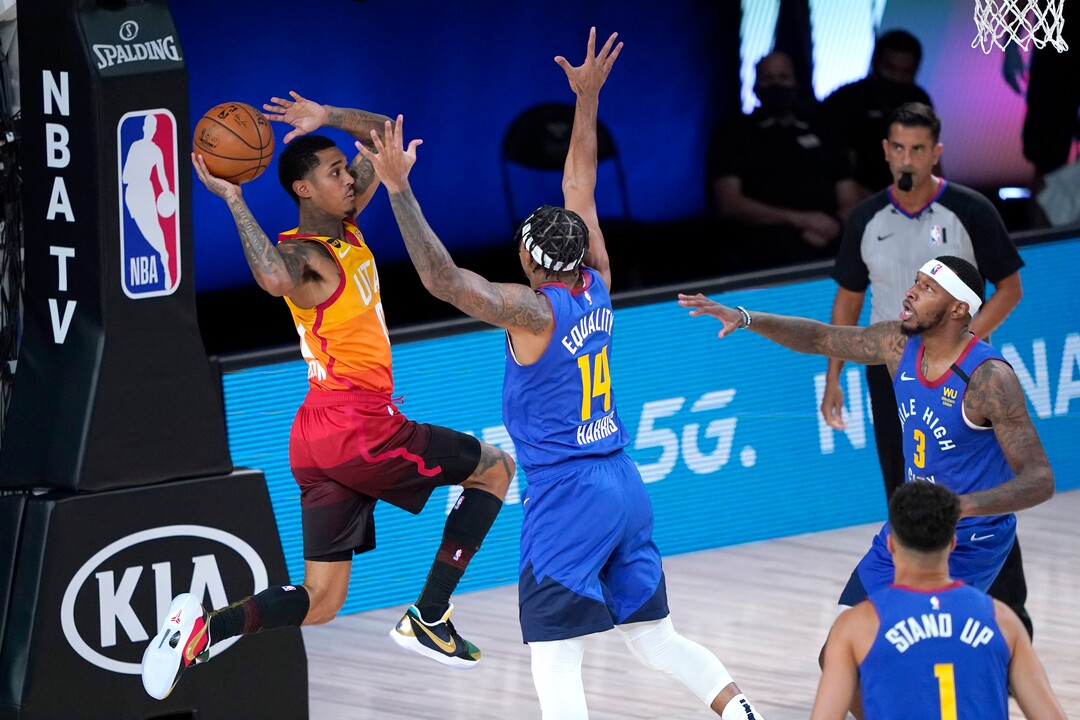 Utah Jazz's Jordan Clarkson, left, looks to pass the ball as Denver Nuggets' Gary Harris (14) defends during the first half of an NBA basketball first round playoff game Sunday, Aug. 30, 2020, in Lake Buena Vista, Fla. (AP Photo/Ashley Landis)