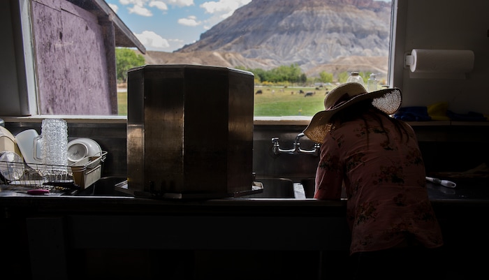 (Leah Hogsten  |  The Salt Lake Tribune) Mesa Farm Market friend and volunteer Dr. Joy Morris cleans the pasteurization vat and utensils after a batch of cheese has been made at the market's large industrial sink overlooking the farm and the animas. Mesa Farm owner Randy Ramsley sells a variety of goats milk cheeses and yogurt at his farm's storefront on Highway 24, east of Capitol Reef and at Tony Caputo's in Salt Lake City. 