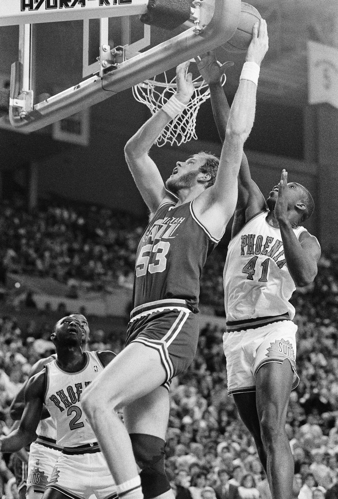 Utah Jazz Mark Eaton goes up and over Phoenix Suns center Mark West while shooting from behind the basket during the game in Phoenix February 7, 1989. (AP Photo/Chad Surmick)