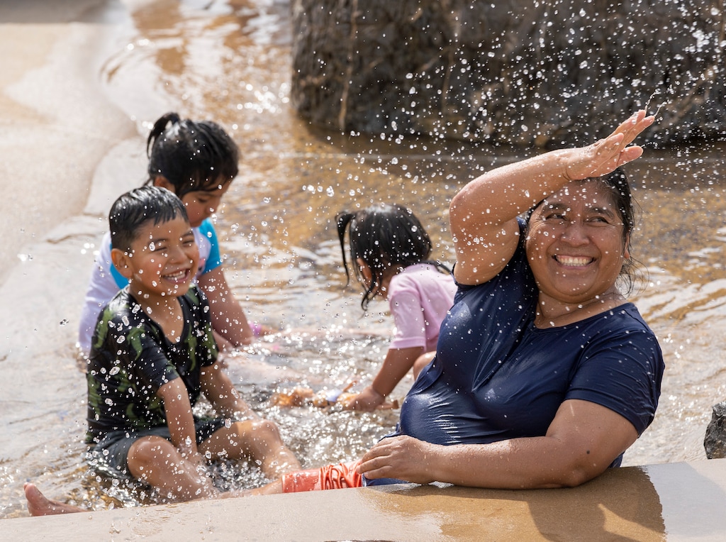 (Rick Egan | The Salt Lake Tribune) Elena Sanchez splashes in the water to cool off with her grandchildren Zareth, Jazi and Zurma, at Fairbourne Station in West Valley City, on Monday, June 7, 2021.