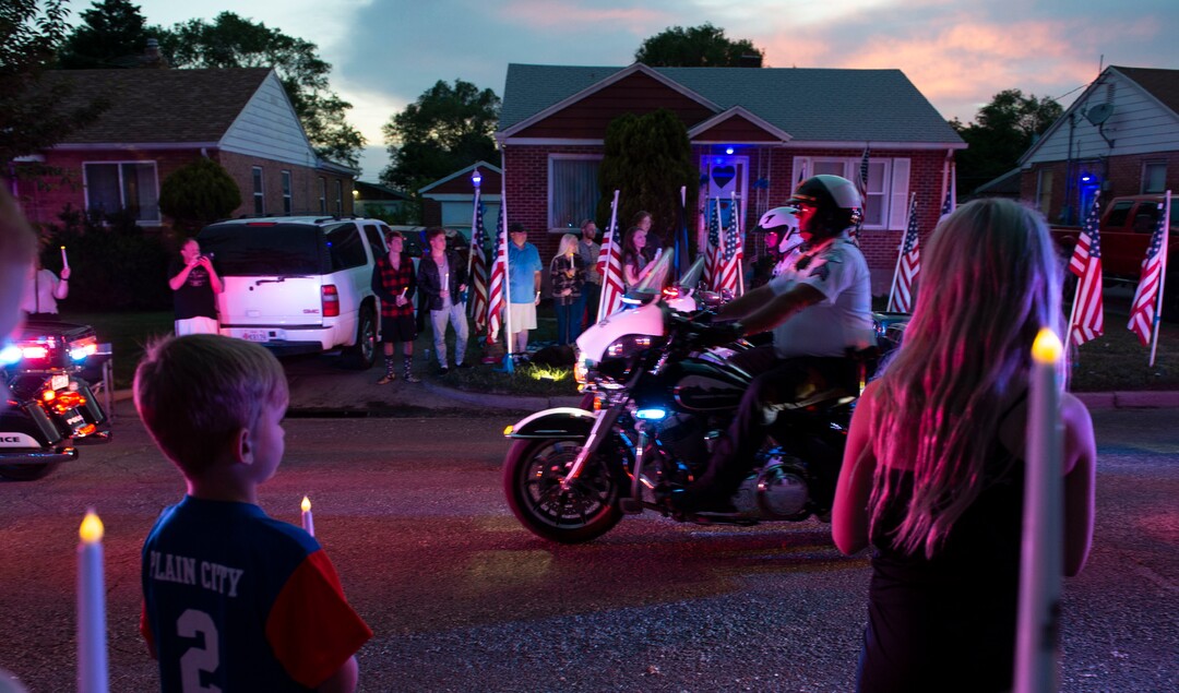 (Leah Hogsten  |  The Salt Lake Tribune) Ogden Police Department vehicles drive past Officer Nate Lyday's childhood home on Custer Avenue in Ogden in a Memorial Procession and Community Vigil in honor of Lyday's life. The procession made its way through five other Ogden landmarks before ending at Lindquist Field.