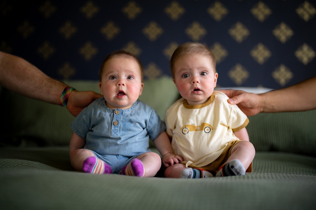 (Trent Nelson  |  The Salt Lake Tribune) Twins Lola and Lincoln are held up by their parents, Josh Valdez and Michael Bangerter, in Riverton on Monday, April 20, 2026. The twins were exposed to measles in March when they were 5 months old.