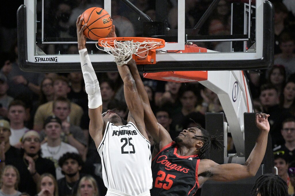 Central Florida forward Taylor Hendricks (25), left, dunks as Houston forward Jarace Walker (25) defends during the first half of an NCAA college basketball game, Wednesday, Jan. 25, 2023, in Orlando, Fla. (AP Photo/Phelan M. Ebenhack)