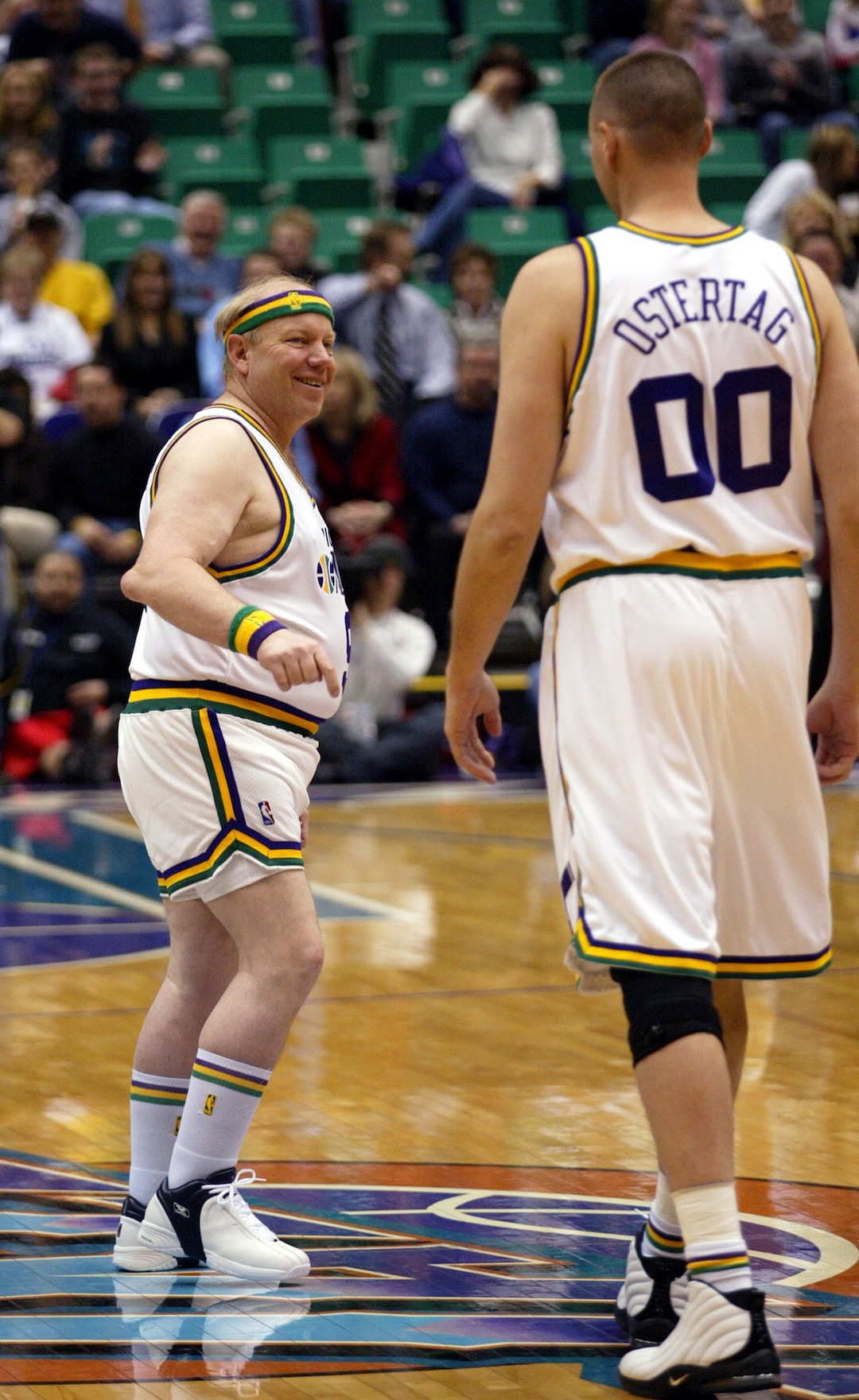 (AP file photo) Utah Jazz owner Larry Miller, left, sports a retro-Jazz uniform as he jokes with Jazz center Greg Ostertag, right, just before tipoff against the Miami Heat Thursday, Jan. 15, 2004, in Salt Lake City. The Jazz celebrated the 25th anniversary of being in Utah by wearing retro-uniforms from 1979.
