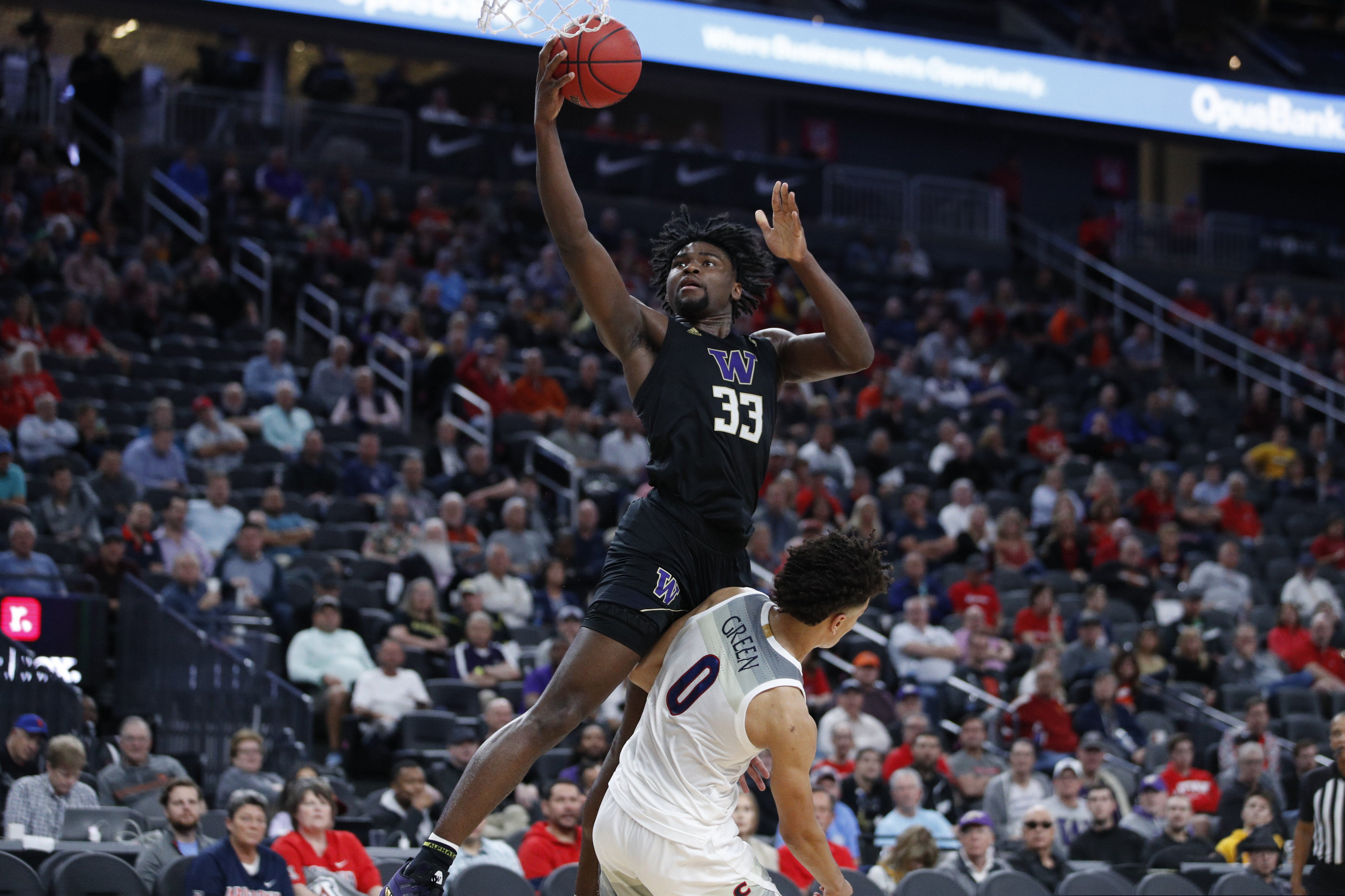 Washington's Isaiah Stewart (33) fouls Arizona's Josh Green (0) during the first half of an NCAA college basketball game in the first round of the Pac-12 men's tournament Wednesday, March 11, 2020, in Las Vegas. (AP Photo/John Locher)