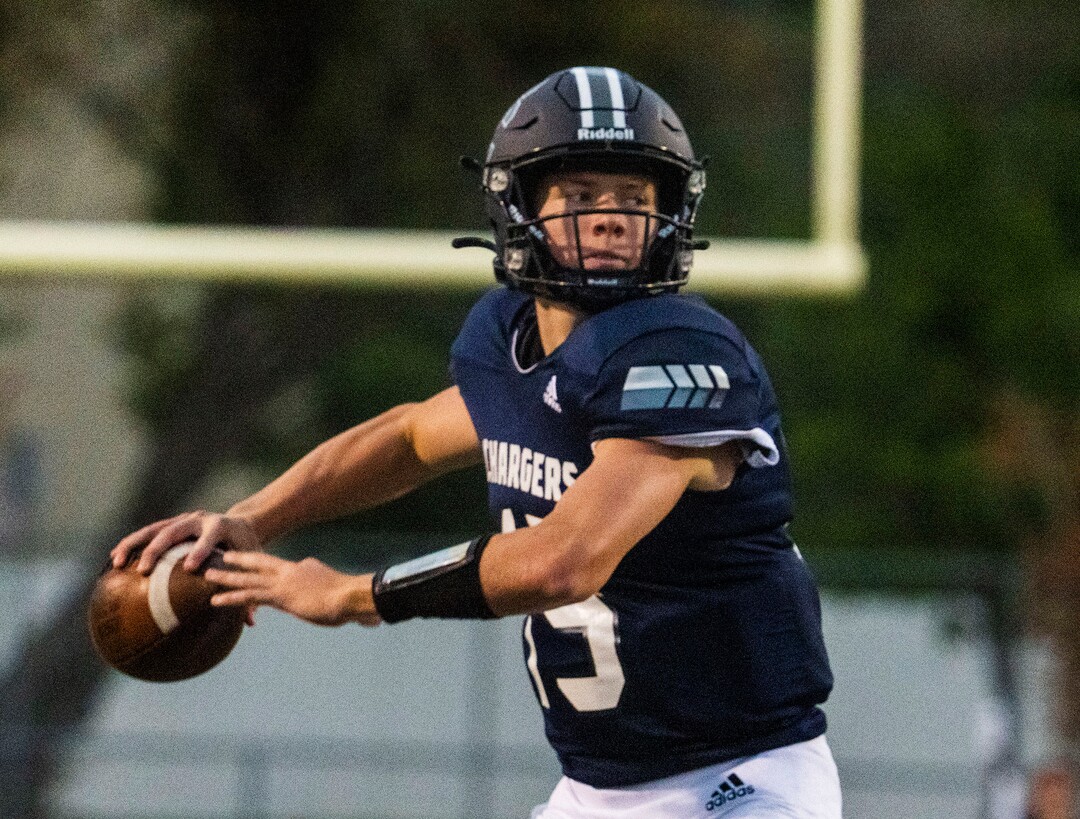 (Rick Egan | The Salt Lake Tribune) Corner Canyon quarterback Devin Brown (15), looks down field as he scrambles with the ball in prep football action between Corner Canyon Chargers and the East Leopards, on Saturday, Aug. 21, 2021.