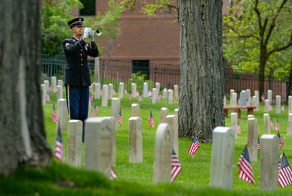(Francisco Kjolseth  |  The Salt Lake Tribune)  Sgt. Aaron Reynolds plays taps as the Association of the United States Army - AUSA - Utah Chapter, hosts a Memorial Day Ceremony at Fort Douglas Cemetery on Monday, May 27, 2019.
