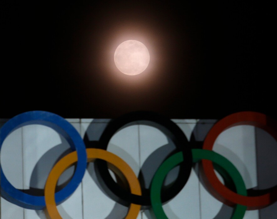 The full moon is seen over the Olympic rings on display at the Peace Gate at the Olympic Park in Seoul, South Korea, Wednesday, Jan. 31, 2018. The moon is putting on a rare cosmic show. It's the first time in 35 years a blue moon has synced up with a supermoon and a total lunar eclipse. (AP Photo/Ahn Young-joon)