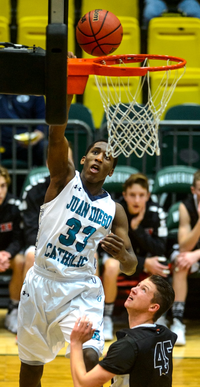 (Steve Griffin | The Salt Lake Tribune) Juan Diego's Kemari Bailey (33) leaps above Hurricane's T.j. Minor (45) for a basket during 4A basketball playoff game at the Utah Valley UniversityÕs UCCU Center in Provo Thursday March 1, 2018.