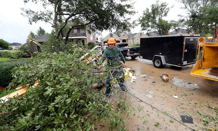 (David J. Phillip | The Associated Press) Henry Isaac removes broken tree limbs after Hurricane Harvey Saturday, Aug. 26, 2017, in Missouri City, Texas.  Harvey rolled over the Texas Gulf Coast on Saturday, smashing homes and businesses and lashing the shore with wind and rain so intense that drivers were forced off the road because they could not see in front of them.