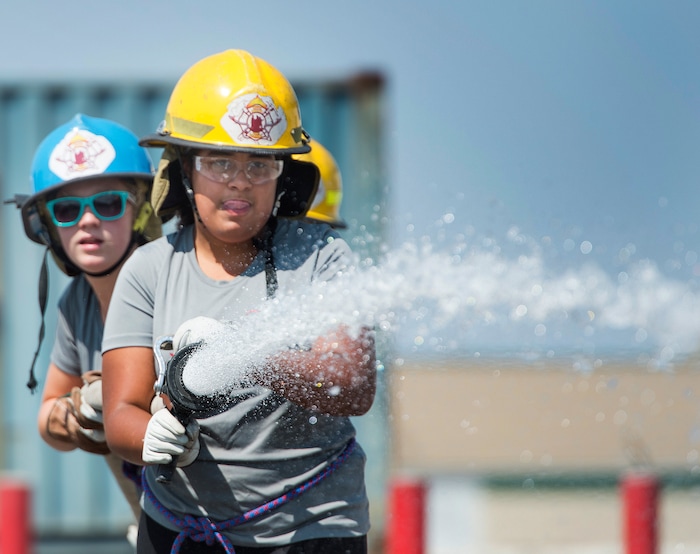 (Rick Egan  |  The Salt Lake Tribune)  Girl scouts Victora and Bianca spray water at a cone, during a firefighter skills relay, while attending Camp Fury.  A dozen Utah Girl Scouts participated in a 3-day camp led by female firefighters. Camp Fury Utah was developed in partnership with the Girl Scouts and local fire and police departments, designed to expose teen girls to careers in public safety and other non-traditional jobs. Saturday, August 5, 2017.


