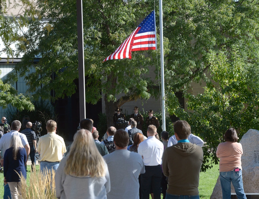 (Al Hartmann  |  The Salt Lake Tribune) 	Utah Dept. of Public Safety employees stand in silence as Utah Highway Patrol honor guard raises the American flag to half staff in a 9-11 flag ceremony in West Valley City Monday Sept. 11.  