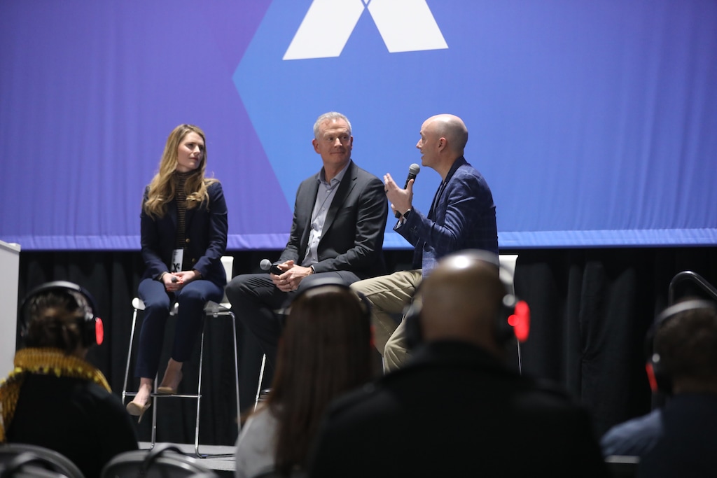 (Office of the Governor) Gov. Spencer Cox, right, talks with Chelsie Bright of Qualtrics, left, and Utah CIO Rich Saunders in a keynote at the X4 Summit at the Salt Palace Convention Center on March 8, 2023.