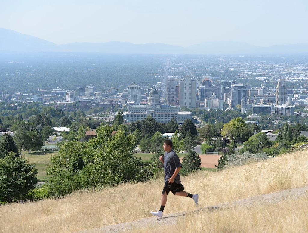 Al Hartmann | The Salt Lake Tribune
Hiker jogs down path from Ensign Peak above Salt Lake City Tuesday July 16. What can be an amazing view of the valley is diminished with an ozone haze. With higher Summer temperatures ozone pollution is climbing into the moderate level.