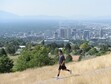 (Al Hartmann | The Salt Lake Tribune) A hiker jogs down the path from Ensign Peak above Salt Lake City in July 2017. What can be an amazing view of the valley is diminished by an ozone haze.