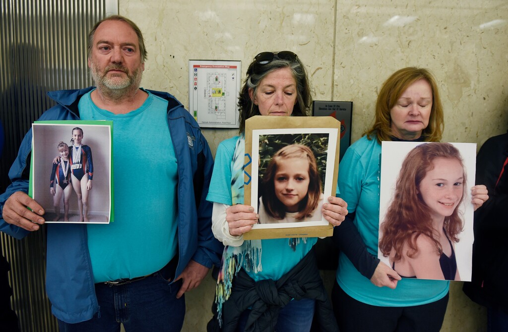 Parents of sexual abuse survivors, from left, Glen Black, of Pinckney, Mich., Tammy Bourque-Stemas, of Dearborn, Mich., and Valerie von Frank, of Okemos,  Mich., stand by the elevator waiting for trustees to arrive for a Michigan State University board meeting, Friday, April 13, 2018, Lansing, Mich. Interim Michigan State University President John Engler said Friday that he regrets the school's response to a woman filing a federal rape lawsuit against the university.  (Clarence Tabb Jr./Detroit News via AP)