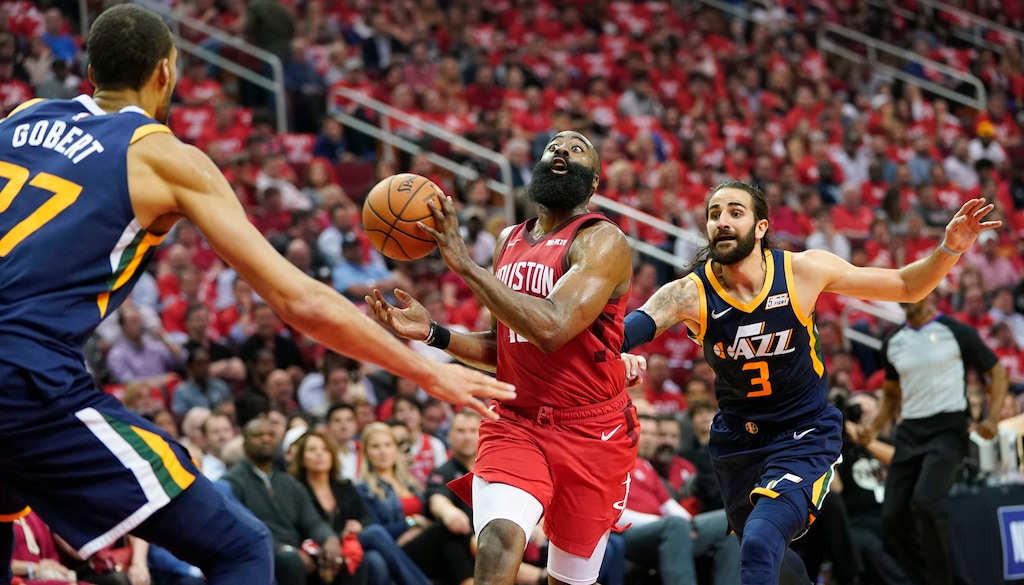 Houston Rockets guard James Harden passes the ball as he drives against Utah Jazz center Rudy Gobert (27) and guard Ricky Rubio (3) during the first half of Game 2 of a first-round NBA basketball playoff series in Houston, Wednesday, April 17, 2019. (AP Photo/David J. Phillip)