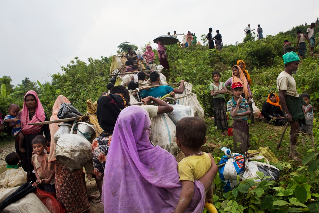 FILE - In this Sunday, Sept. 3, 2017, file photo, Myanmar's Rohingya ethnic minority refugees walk after crossing the Bangladeshi border near Cox Bazar's Kanjopara area Bangladesh. The U.N. refugee agency is reporting a surge in the number of Rohingya Muslims who have crossed into Bangladesh from Myanmar, with an estimated 270,000 arriving in the last two weeks. (AP Photo/Bernat Armangue, File)