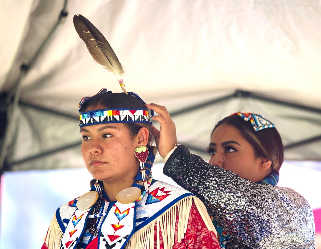(Rick Egan | The Salt Lake Tribune) Gorgeous Lee, from Springville gets help from Tiffany Singer 22, from provo, as she prepares for her dance at the Native American celebration and Powwow at Liberty Park, on Friday, July 23, 2021.