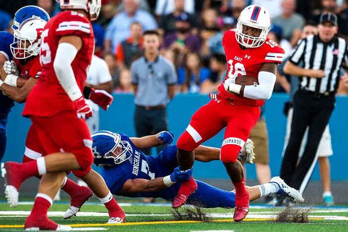 (Chris Detrick  |  The Salt Lake Tribune)  East's Josh Parker (18) runs past Bingham's Brayden Cosper (7) during the game at Bingham High School Friday, August 25, 2017. Bingham is winning the game 24-17 at halftime. 