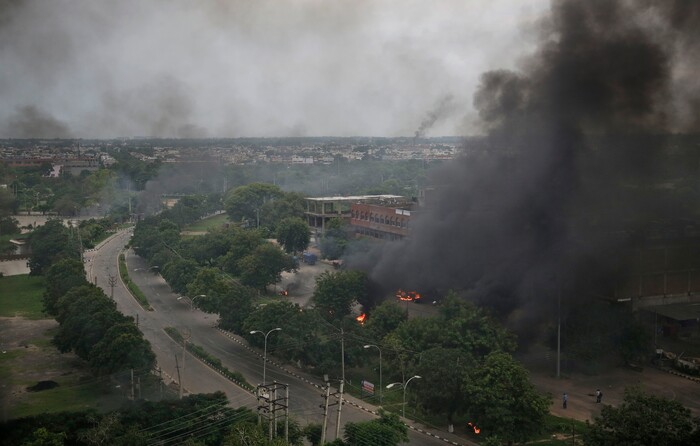 Smoke billows after supporters of the Dera Sacha Sauda sect set vehicles on fire near in Panchkula, India, Friday, Aug. 25, 2017.  Deadly riots have broken out in a north Indian town after a court convicted a guru of raping two of his followers. Mobs also attacked journalists and set fire to government buildings and railway stations. (AP Photo/Altaf Qadri)