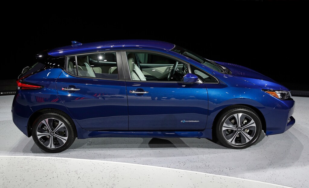 (John Locher | AP file photo) The 2018 Nissan Leaf is on display during an unveiling event in Las Vegas in September 2017. Electric car prices are falling, but they still cost more than equivalent gas models because of their expensive batteries.
