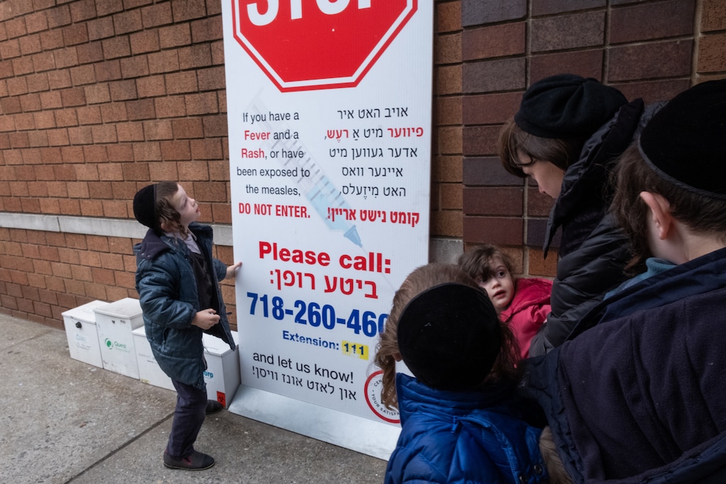 (Sharon Pulwer | The Washington Post) Ultra-orthodox Jewish children gather outside a health care branch where vaccines against measles are being given on Tuesday, April 9, 2019.