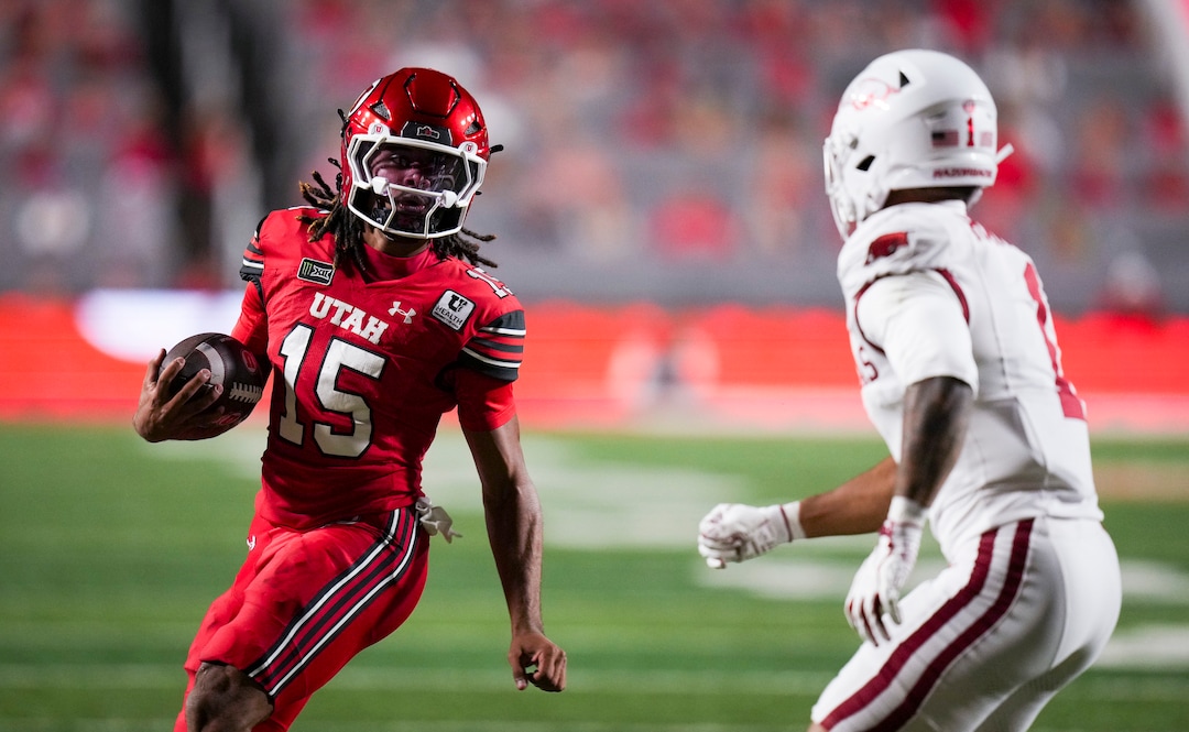 (Bethany Baker  |  The Salt Lake Tribune) Utah Utes quarterback Byrd Ficklin (15) avoids a tackle from Arkansas Razorbacks defensive back Christian Harrison (1) during the game between the Utah Utes and the Arkansas Razorbacks in Salt Lake City on Saturday, Sept. 12, 2026.