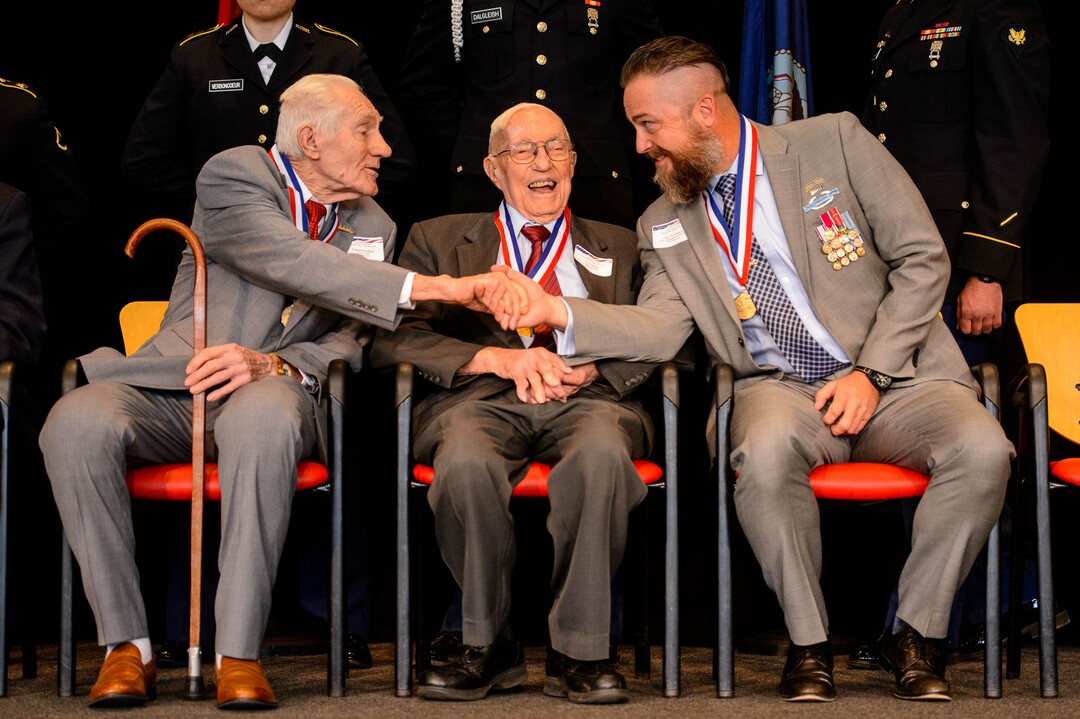 (Trent Nelson  |  The Salt Lake Tribune)
World War II veterans Leland Hortman and Earl Jacklin, and Afghanistan and Iraq veteran Glenn Johnson shake hands while being recognized at the Veterans Day Commemoration at the University of Utah in Salt Lake City on Monday, Nov. 11, 2019.
