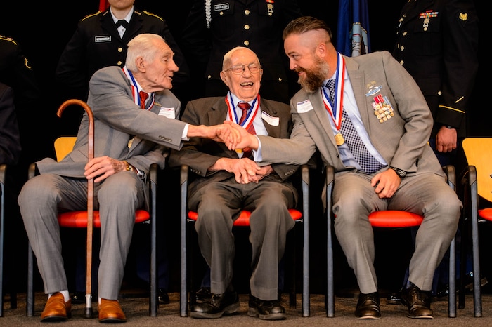 (Trent Nelson | The Salt Lake Tribune)
World War II veterans Leland Hortman and Earl Jacklin, and Afghanistan and Iraq veteran Glenn Johnson shake hands while being recognized at the Veterans Day Commemoration at the University of Utah in Salt Lake City on Monday, Nov. 11, 2019.