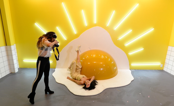 (Francisco Kjolseth  |  The Salt Lake Tribune)  Jiajing Yi poses for Maiya Buck in the egg room at Hall of Breakfast, a quirky new art exhibit that celebrates the first meal of the day. Each room celebrates a favorite breakfast food from bacon to cereal to coffee. The exhibit runs through July 9.