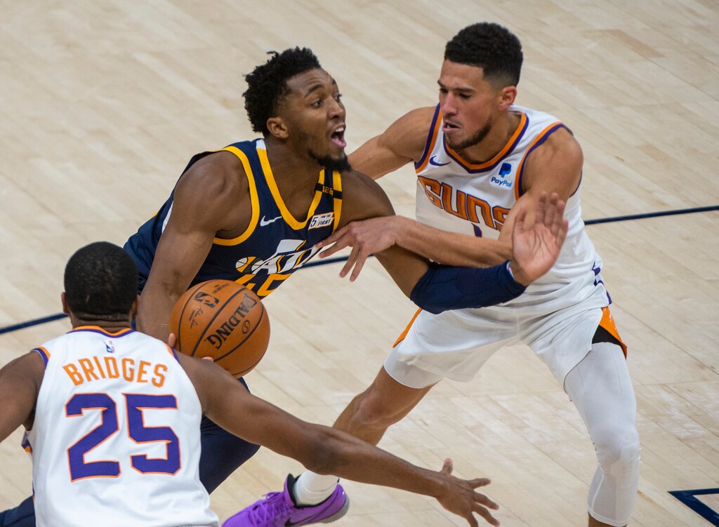(Rick Egan | The Salt Lake Tribune) Phoenix Suns guard Devin Booker (1) gets his hands on Utah Jazz guard Donovan Mitchell (45), in NBA action between the Utah Jazz and the Phoenix Suns, on Thursday, Dec. 31, 2020.